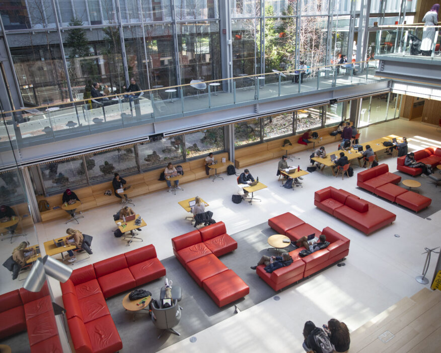 Two-floor lobby of Smith Campus Center, which has red couches and big window walls.