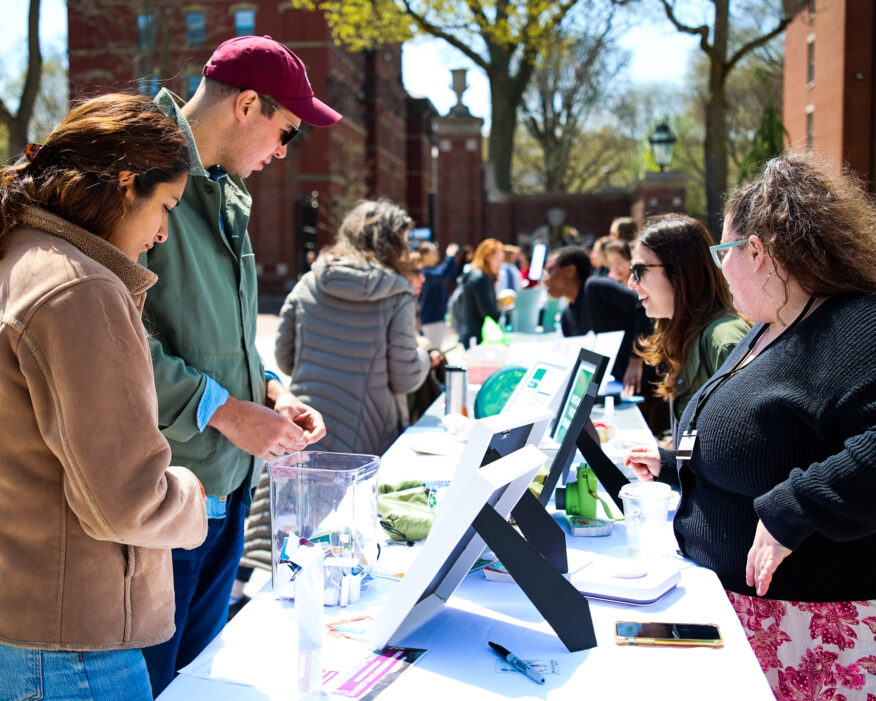 People talk at an Earth Day event tabling.